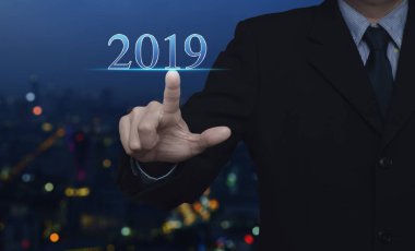 Renkli gece ışık şehir kule ve gökdelen, mutlu yeni yıl 2019 takvim kapak konsepti 2019 metin üzerine basarak işadamı bulanıklığı