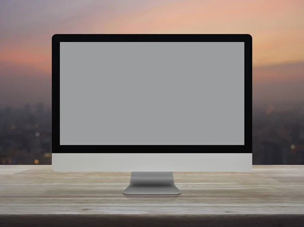 暖かい光日没の都市景観のぼかしに木製のテーブルの上の灰色の画面とデスクトップの現代コンピューターのモニター — ストック写真