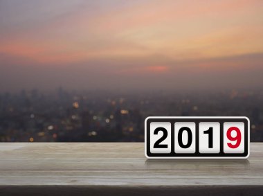 Retro flip saat ahşap masa üzerinde 2019 metin ile bulanıklık cityscape sıcak ışık sundown, mutlu yeni yıl 2019 kapak konsepti