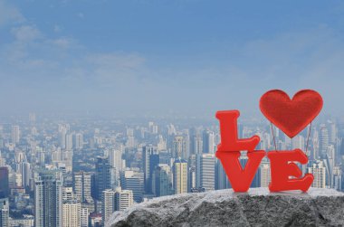 Kırmızı aşk alfabesi ve kumaş kalp ballon modern şehir Kulesi, Ofis Binası ve gökdelen, Sevgililer günü kavramı üzerinde rock dağda