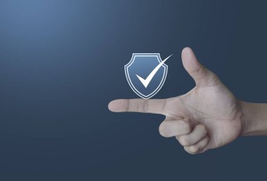 Güvenlik kalkanı parmak üzerinde ışık degrade mavi tonu arka plan, teknoloji Internet cyber security ve anti virüs kavramı üzerindeki onay işareti düz simgesiyle
