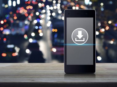 Download düz ahşap masa üzerinde modern akıllı cep telefonu ekran simgesine bulanıklık otomobil City, iş Internet kavramı ile renkli gece ışık şehir