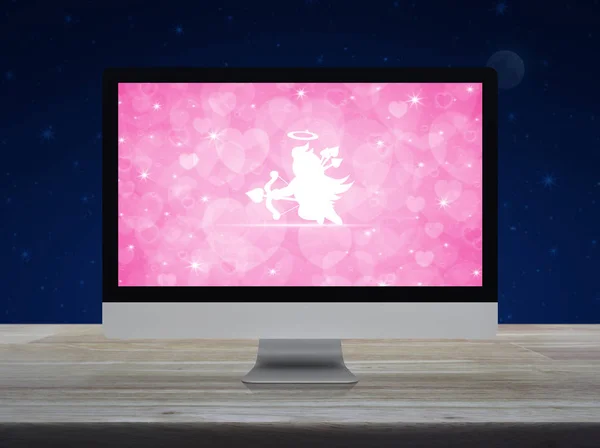 ファンタジー夜空と月 バレンタインデー概念でデート オンライン ビジネス インターネット上の木製のテーブルの上のピンクの愛心画面とデスクトップの現代コンピューターのモニター上のキューピッド フラット アイコン — ストック写真
