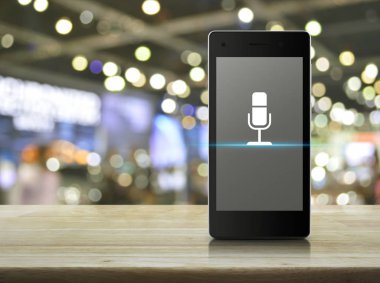 Mikrofon düz ahşap masa üzerinde modern akıllı cep telefonu ekran simgesine bulanıklık ışık ve gölge, Alışveriş Merkezi, online iletişim iş kavramı