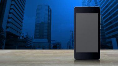 Ofis kulesi ve gökdelen, iş güvenliği ve güvenlik online konsepti üzerinde ahşap masa üzerinde modern akıllı cep telefonu ekranı üzerine kapalı kamera yassı simgesi