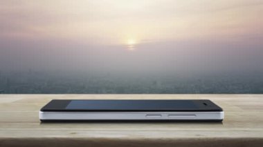 Gün batımında şehir kulesi ve gökdelen üzerinde ahşap masa üzerinde modern akıllı cep telefonu ekranında Motosiklet düz simgesi, vintage tarzı, İş teslim hizmeti online kavram