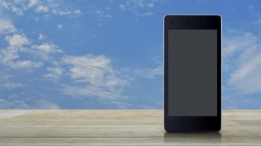 Ahşap masa ile beyaz bulutlar, online iletişim iş kavramı mavi gökyüzü üzerinde modern akıllı cep telefonu ekranda belge düz simgesi