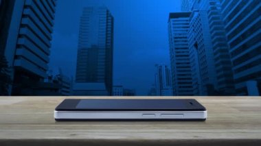 Modern akıllı cep telefonu ekranındaki mikrofon yassı simge ofis kulesi ve gökdelen üzerinde ahşap masa, iş iletişimi online konsept