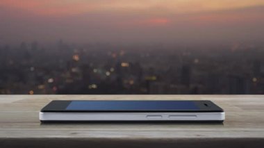 Sıcak ışık günbatımı nda cityscape bulanıklık üzerinde ahşap masada modern akıllı cep telefonu ekranında ücretsiz teslimat kamyon düz simgesi, İş ulaşım online kavram
