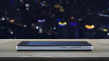 Bilgi renkli gece ışık şehir kulesi ve gökdelen, İş müşteri hizmetleri ve destek online kavramı üzerinde bulanıklık üzerinde ahşap masa üzerinde modern akıllı cep telefonu ekranında düz simge işareti