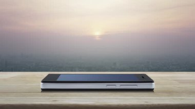 Modern akıllı cep telefonu ekranındaki mikrofon düz simgesi ahşap masa üzerinde ve günbatımında gökdelen, klasik tarz, iş iletişimi çevrimiçi konsepti