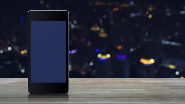 银行平面图标现代智能手机屏幕上的木桌上模糊五颜六色的夜光城市塔和摩天大楼 商业移动银行概念 — 图库视频影像