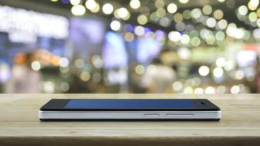 Banka düz simgesi modern akıllı cep telefonu ekranı ahşap masa üzerinde bulanık ışık ve alışveriş merkezinin gölgesi, iş bankacılığı online konsept