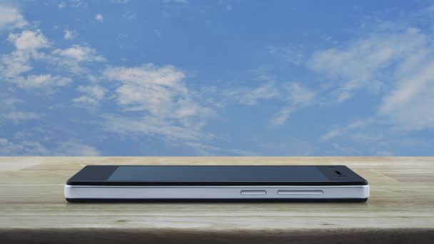 白い雲と青い空の上に木製のテーブルの上に現代のスマート携帯電話の画面上のフラットアイコンをダウンロード 技術インターネットオンラインコンセプト — ストック動画