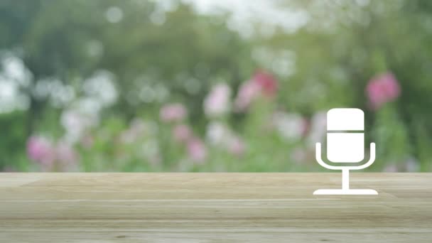 ブラーピンクの花と庭の木の上に木製のテーブルの上にマイクフラットアイコン ビジネスコミュニケーションコンセプト — ストック動画