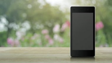 Modern akıllı cep telefonu ekranındaki yasanın düz simgesi ahşap masadaki bulanık pembe çiçek ve bahçedeki ağaç üzerinde iş hukuku hizmetleri online konsepti