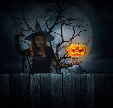 Cadılar Bayramı cadısı ve balkabağı canavarı kafası ölü ağacın, dolunayın ve bulutlu gökyüzünün üzerinde duran Cadılar Bayramı gizemi kavramı.