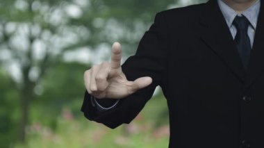 İş adamı parktaki bulanık çiçek ve ağaç üzerine belgenin düz simgesine basıyor, Teknoloji İnternet konsepti