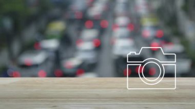 Kamera düzlüğü simgesi ahşap masa üzerinde kalabalık saatte arabalar ve şehirdeki yollar, iş kameraları servis hizmeti konsepti