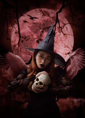 Cadılar Bayramı cadısı elinde kafatası, kilise, karga, kuşlar, ölü ağaç, dolunay ve bulutlu gökyüzü, Cadılar Bayramı gizemi