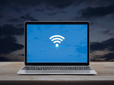 Günbatımı sehpası üzerinde modern dizüstü bilgisayarı olan Wi-Fi düz ikonu, Teknoloji İnternet çevrimiçi kavramı