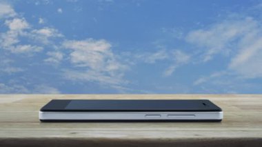 Modern akıllı cep telefonu ekranında bedavadan dağıtım kamyonu düz simgesi beyaz bulutlu ahşap gökyüzü üzerinde ahşap masa, iş ulaşımı çevrimiçi konsept