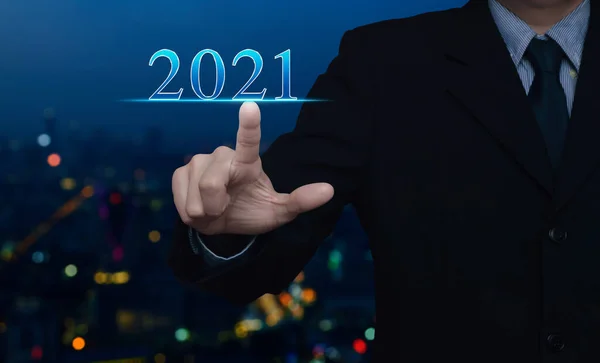 商务人士将2021年的文本压在模糊的彩色夜光 现代化的城市塔和摩天大楼之上 祝2021年农历新年吉祥 — 图库照片