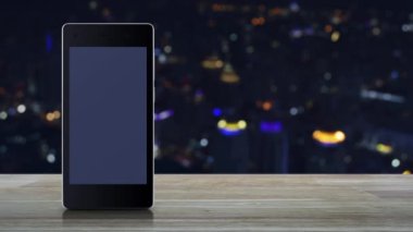 Harita nokta konum düğmesi üzerinde modern akıllı cep telefonu ekranı ahşap masa üzerinde bulanık renkli şehir kulesi ve gökdelen, harita işaretleyici çevrimiçi konsept