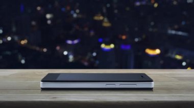 Modern akıllı cep telefonu ekranında fotokopi alanı olan ev simgesi ahşap masa üzerinde bulanık renkli gece lambası şehir kulesi ve gökdelen üzerinde, Business gayrimenkul online konsepti