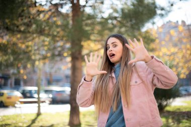 Genç, güzel, beyaz bir kadın parkta korkuyor.  