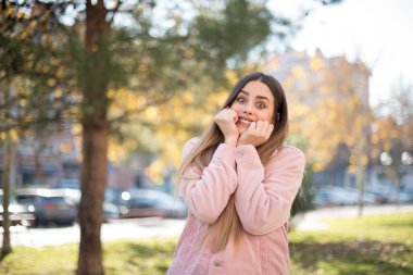 Genç ve güzel bir kadın parkta eğleniyor.  