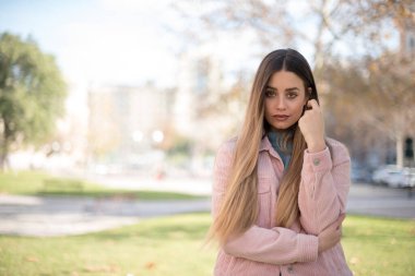Hüzünlü, genç bir kadının yüzünün birbirine baktığını, önemli bir şeyi düşünürken üzgün olduğunu ve el ele durduğunu düşün. Sarışın kadın dışarıda duruyor..