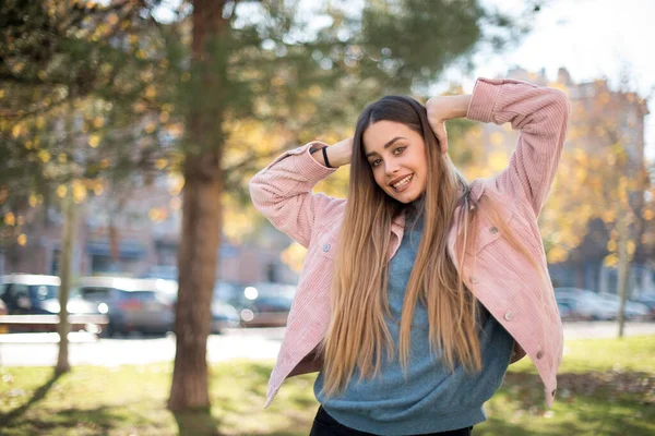 Genç ve güzel bir kadın parkta dinleniyor.  