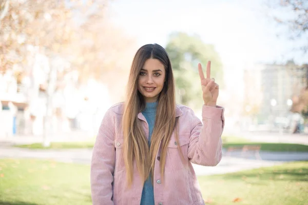 Feliz Bela Jovem Loira Vestindo Jaqueta Rosa Mostrando Sinal Paz — Fotografia de Stock