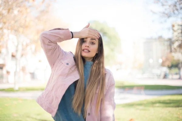 Parkta Alnında Pembe Ceketi Olan Genç Güzel Sarışın Bir Kadın — Stok fotoğraf