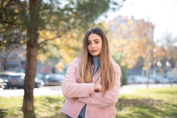  Çekici, başarılı bir kızın portresi, açık havada dururken kendine güvenen bir ifadeyle geniş bir gülümseme.