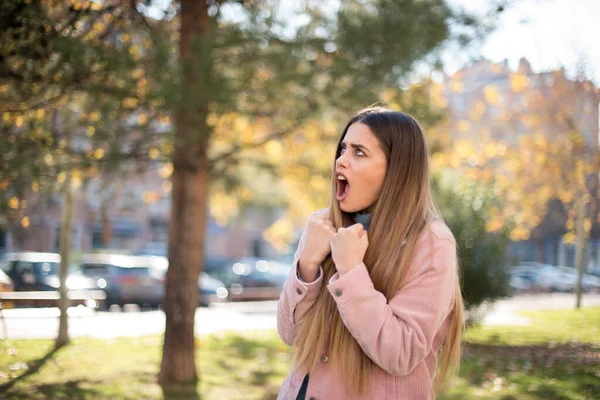 Genç ve güzel sarışın hippi kadın, gündelik giysiler giyip çılgınlığı kutluyor ve başarıya hayret ediyor. Kolları açık, gözleri açık, heyecanla bağırıyor. Kazanan konsept. Dışarıda dikiliyorum.