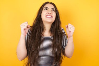 Uzun saçlı, heyecanlı, beyaz bir kadın. Yumruklarını büyük bir mutlulukla kaldırıyor. Maçı kazandıktan sonra keyfi yerine geliyor. Genç şampiyon hedeflerine ulaştığına seviniyor. Zafer ve zafer kavramı.