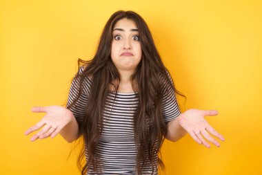 Kafası karışmış, kafası karışık, uzun saçlı, omuzlarını silkip 