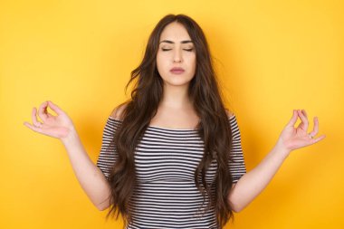 Meditasyon, din ve ruhani uygulamalar. Güzel, genç bir kadın sabah uyandıktan sonra yoga yapıyor, gözlerini kapalı tutuyor, parmaklarını Mudra jestinde tutuyor..