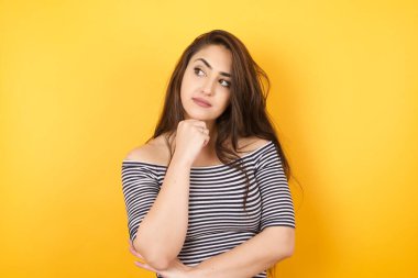 Yüz ifadeleri ve duygular. Düşünceli, genç ve güzel bir kız başının altında el ele tutuşuyor..