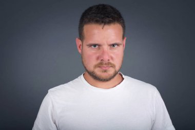 Oval yüzlü öfkeli bir gencin portresi, mavi gözlü, beyaz tişörtlü, kaşlarını çatan bir şeyden hoşnutsuz. Gri saçlı, güzel bir kadın..