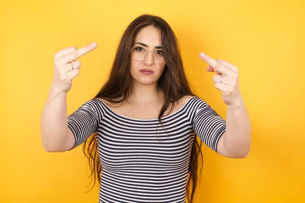 stock image Young  woman showing middle fingers  in studio on isolated background 