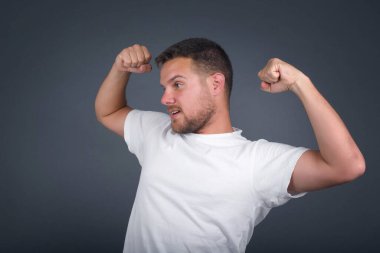 Evet, ben kazandım. Çekici, keyifli ve heyecanlı beyaz erkek öğrencinin portresi zafer ve zaferle yumruğunu kaldırıyor mutluluktan sırıtarak başarı elde ediyor..