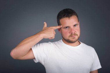 Mutsuz sarışın adam dudaklarını kıvırıyor ve intihar jesti yapıyor, her şeyden bıkmış, sinagogda elle çekim yapıyor, stüdyo arka planında izole edilmiş. Erkek jestleri kapalı alanda kendini öldürmeye çalışır.