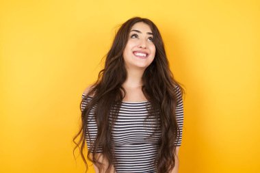 Sıradan giyinmiş, düz saçlı esrarengiz bir gülümsemeyle yukarı bakan gizemli büyüleyici kadının portresi. Güzel, gülümseyen kız ayağa bakıyor. 