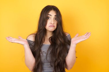 Güzel bir kadın ifadeden şüphe eder, şaşırır ve şaşırır. Belirsiz bir gelecek omuz silker. Stüdyo duvarına karşı durur..