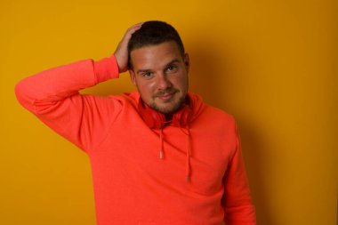 Sarı duvara yaslanmış genç bir adam. 