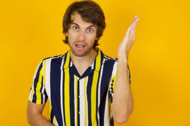 What the hell are you talking about, nonsense. Studio shot of frustrated man hair gesturing with raised palm, frowning, being displeased and confused with dumb question 