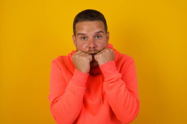 Stüdyoda yumrukları olan yakışıklı bir genç.